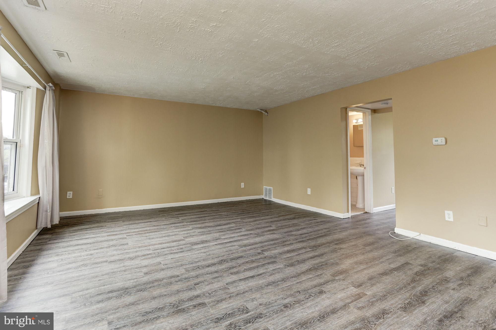 1925 Addison Road South District Heights, MD 20747 - Photo 3 of 9 an empty room with wooden floor and windows
