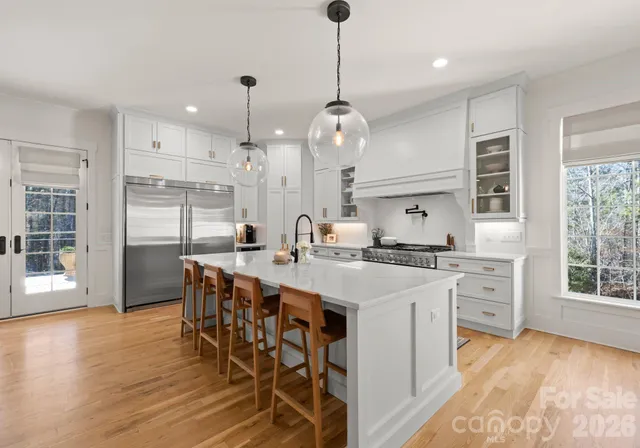 a large kitchen with kitchen island a island a sink a stove and a wooden floor