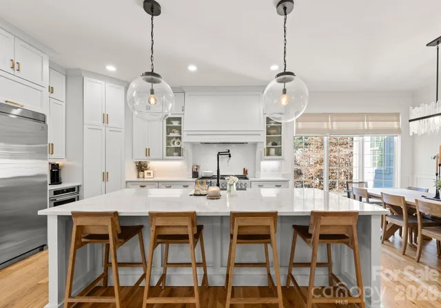 a kitchen with kitchen island granite countertop a table and chairs in it