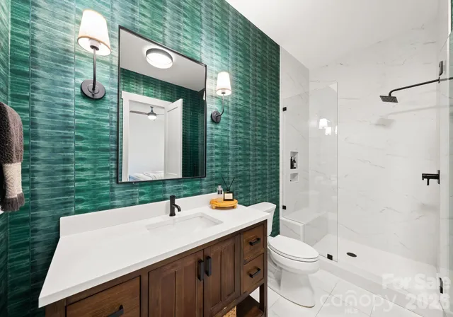 a bathroom with a granite countertop sink toilet and shower