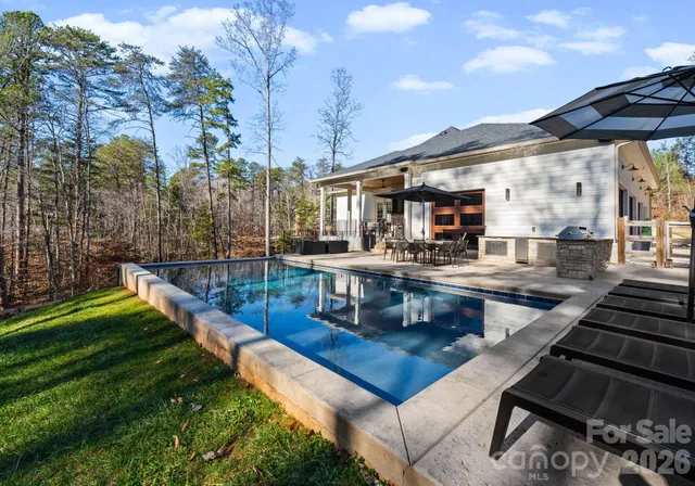 a view of a patio with table and chairs potted plants and a large tree