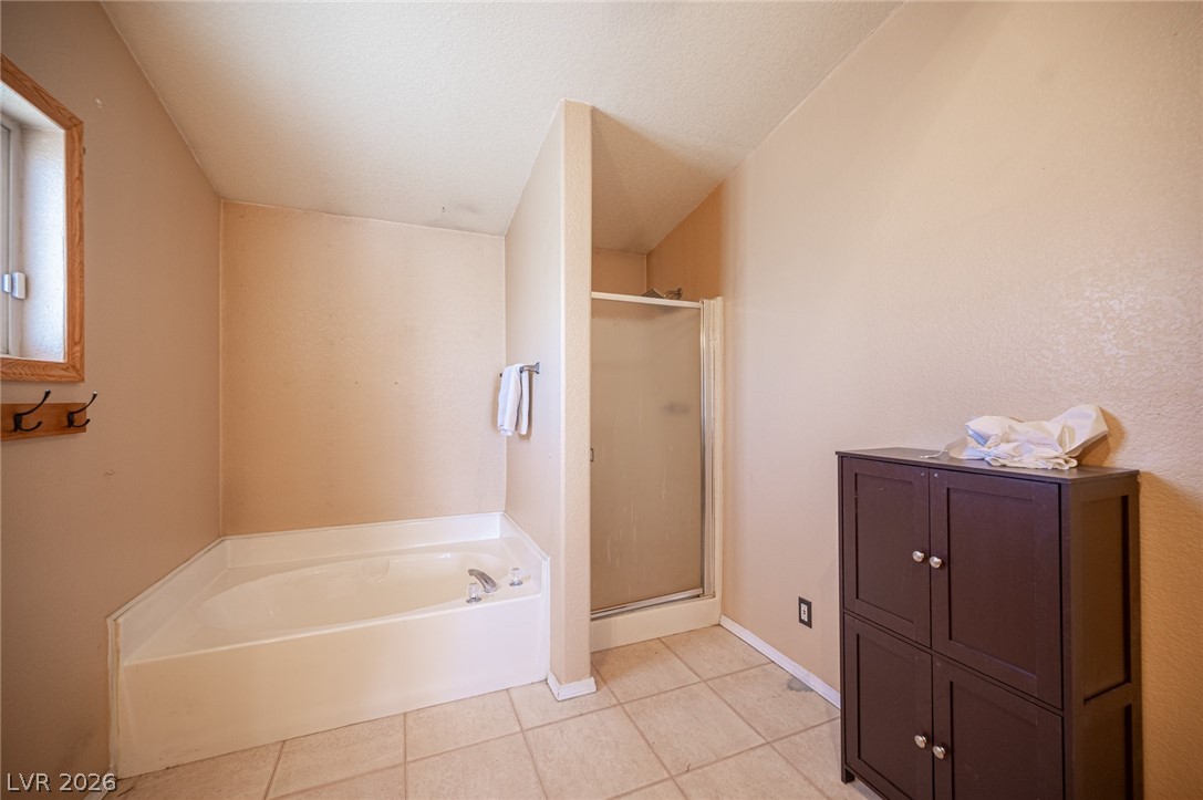 3200 Maple Road Pahrump, NV 89048 - Photo 38 of 53 A corner soaking tub and glass-enclosed shower create a practical and refreshing bathing experience.