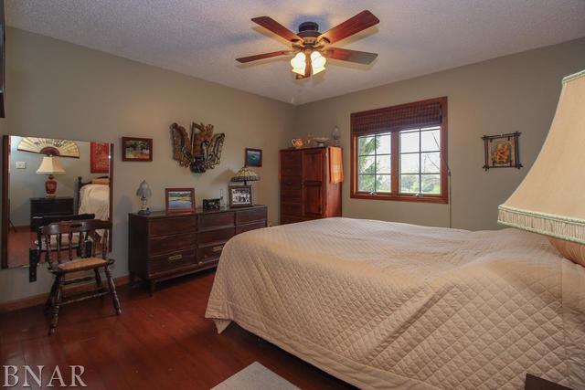 7647 White Oaks Road Clinton, IL 61727 - Photo 18 of 30 a bedroom with a bed and a chandelier