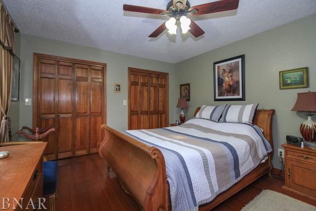 7647 White Oaks Road Clinton, IL 61727 - Photo 21 of 30 a spacious bedroom with a bed and a chandelier