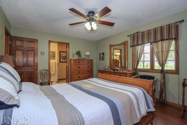 7647 White Oaks Road Clinton, IL 61727 - Photo 22 of 30 a bedroom with a bed and dresser with wooden floor