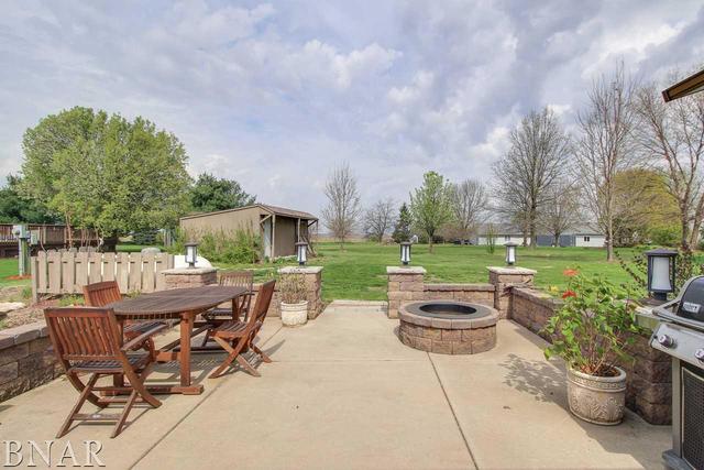 7647 White Oaks Road Clinton, IL 61727 - Photo 27 of 30 a view of a patio with a dining table and chairs with a fire pit and a yard