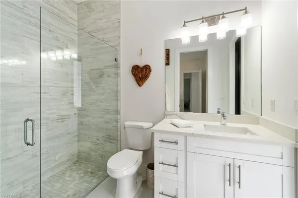 a white bath tub sitting next to a bathroom sink and vanity