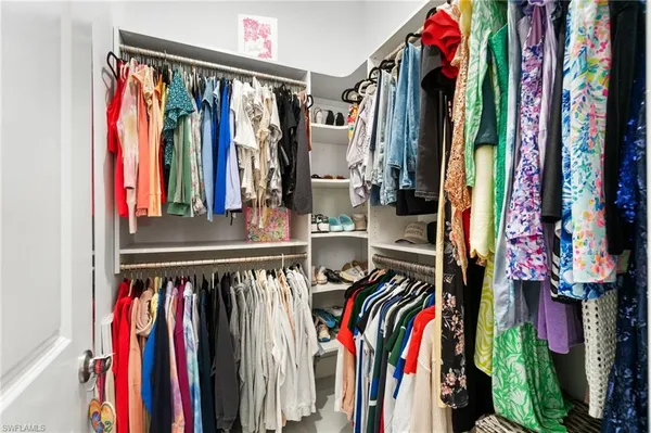 a view of walk in closet with clothes and shoes