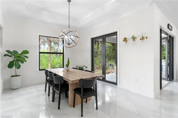 a kitchen with stainless steel appliances a stove a refrigerator a microwave oven a sink with a dining table and chairs