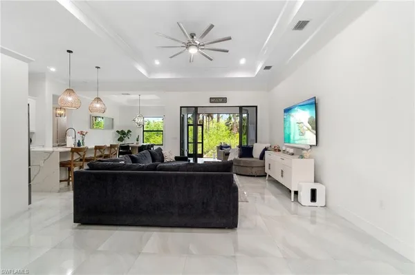 a large kitchen with kitchen island a stove a sink a center island and wooden floor