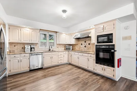a kitchen with granite countertop white cabinets and sink
