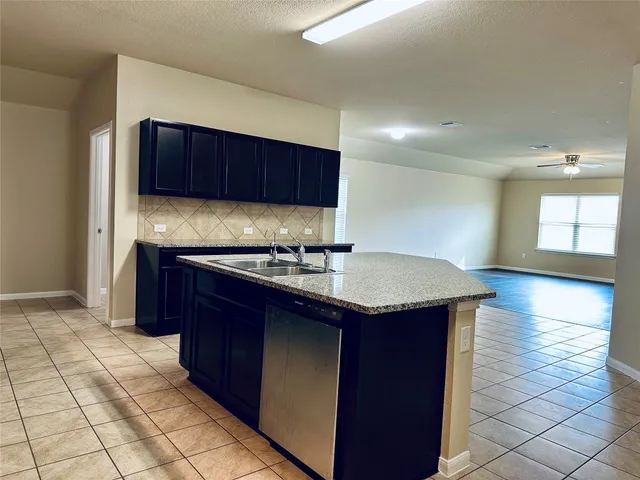 a kitchen with granite countertop a sink and a stove