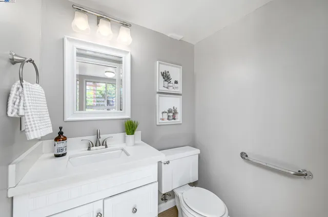 a bathroom with a sink vanity mirror and toilet
