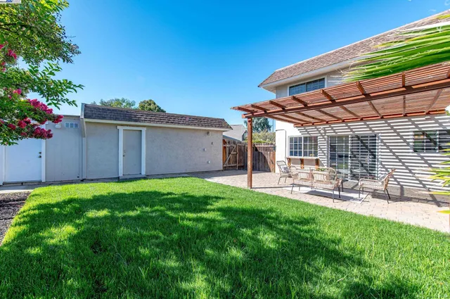 a view of a backyard with table and chairs and potted plants