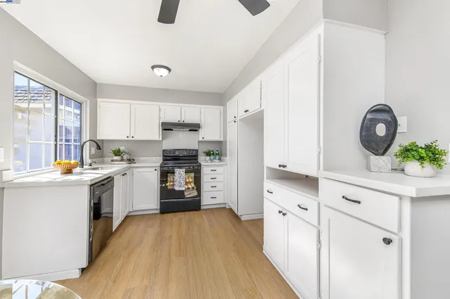 a kitchen with white cabinets and stainless steel appliances