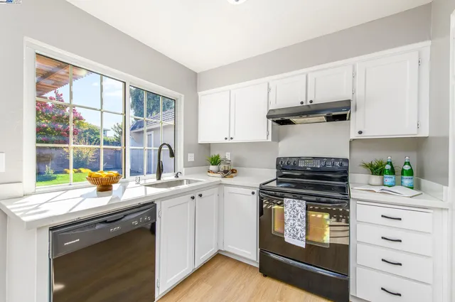 a kitchen with a stove a sink and a window