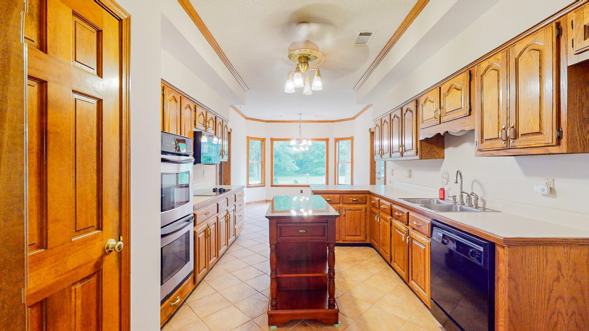 5086 Fleming Road Collierville, TN 38017 - Photo 6 of 25 Kitchen with sink, a center island, light tile patterned floors, and black appliances