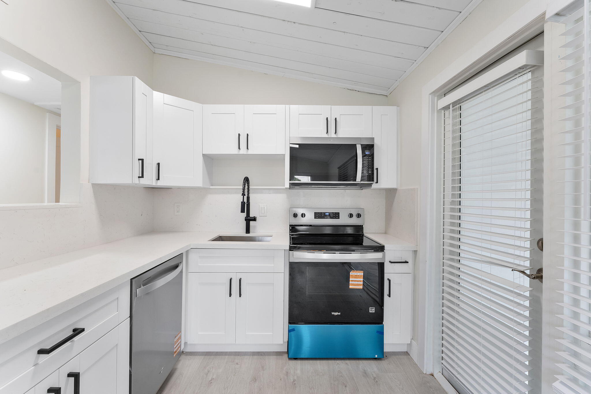 474 Enfield Street Boca Raton, FL 33487 - Photo 18 of 40 a kitchen with stainless steel appliances a stove sink microwave and cabinets