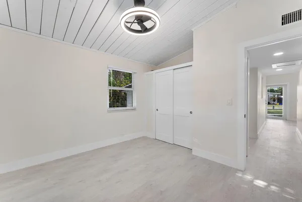 an empty room with windows and closet