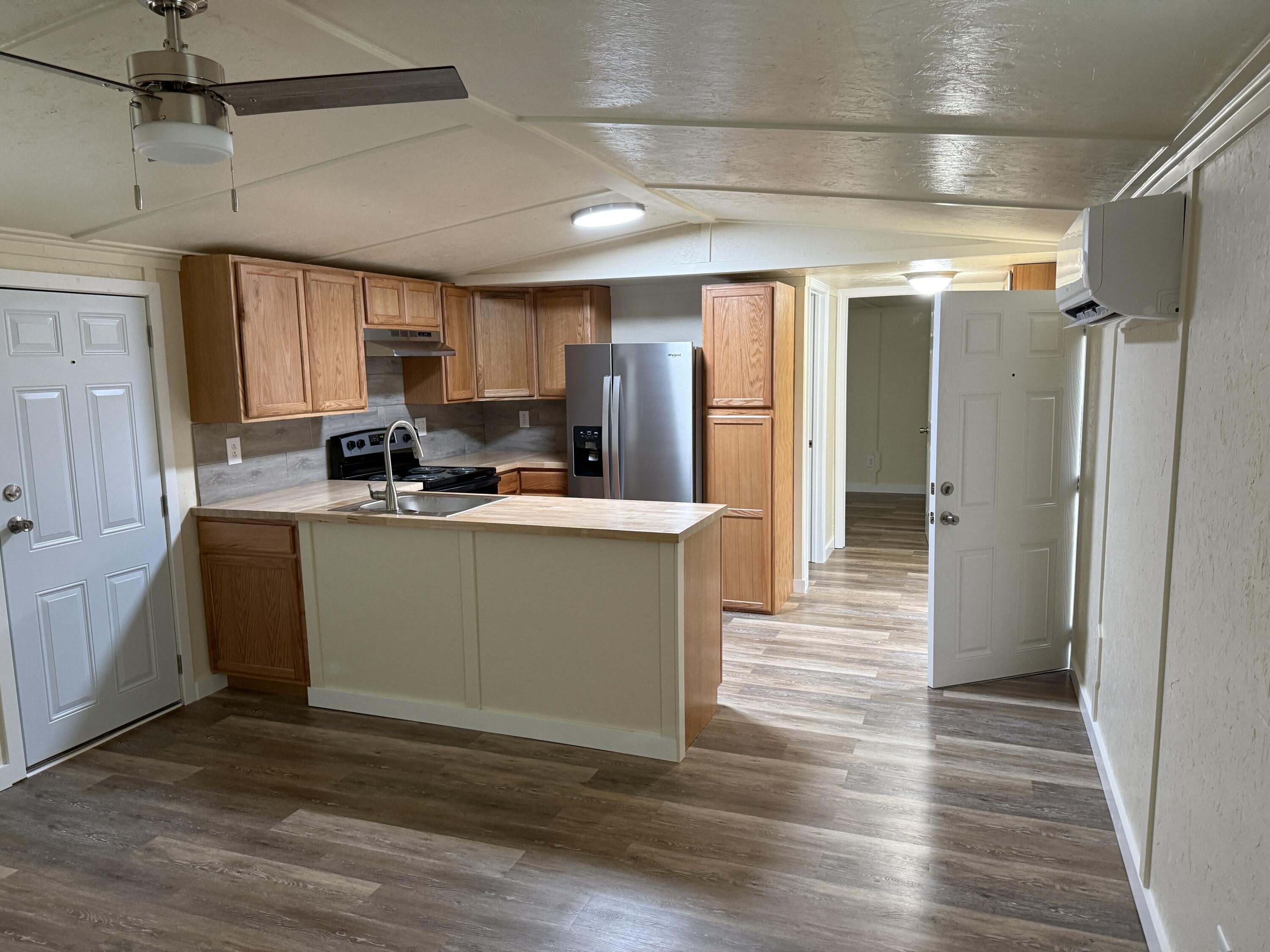 268 Briar Mountain Road Rocky Mount, VA 24151 - Photo 3 of 11 a kitchen with stainless steel appliances granite countertop a refrigerator a sink dishwasher a stove and white countertops with wooden floor
