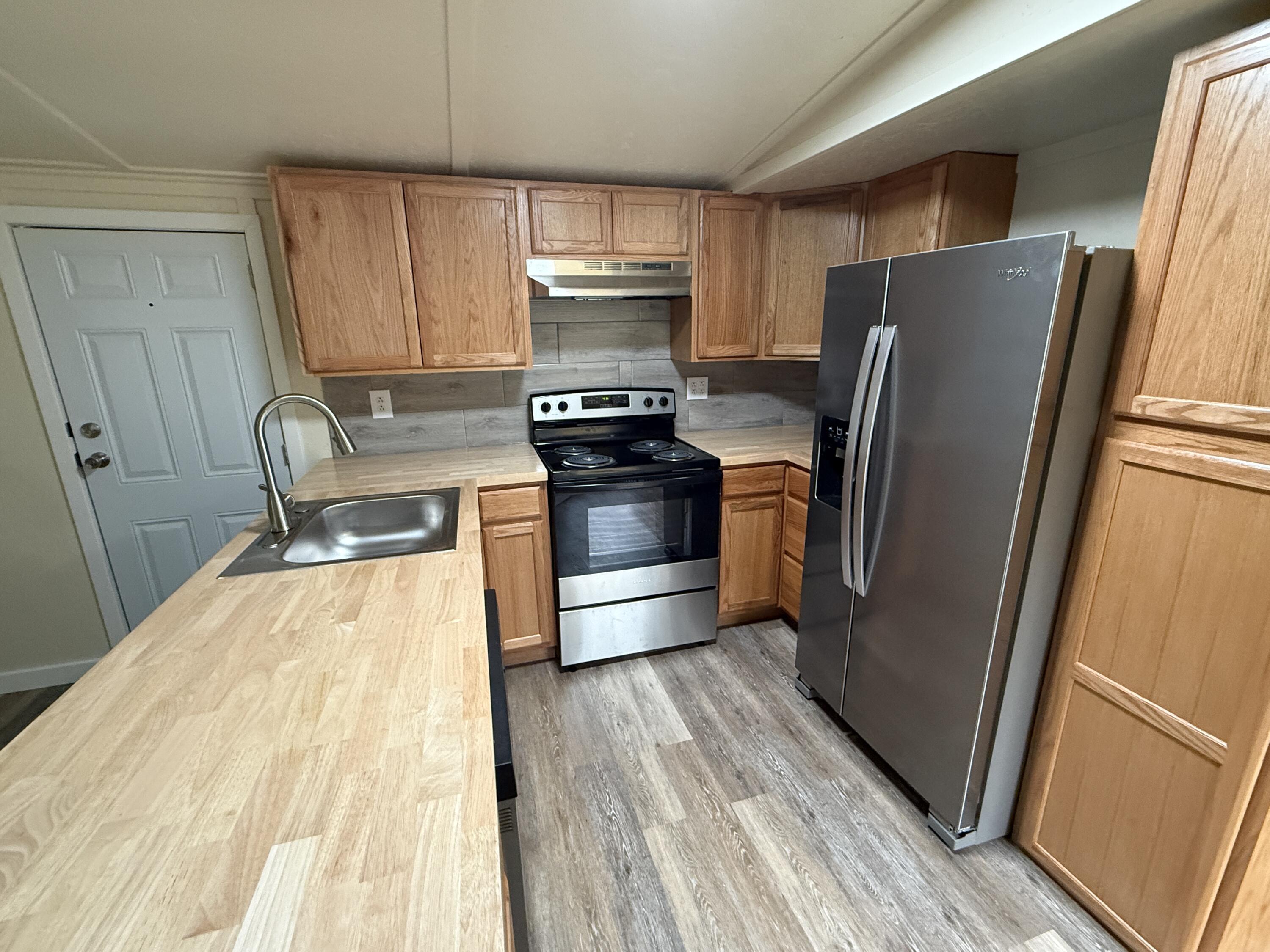 268 Briar Mountain Road Rocky Mount, VA 24151 - Photo 4 of 11 a kitchen with granite countertop a refrigerator and a stove top oven