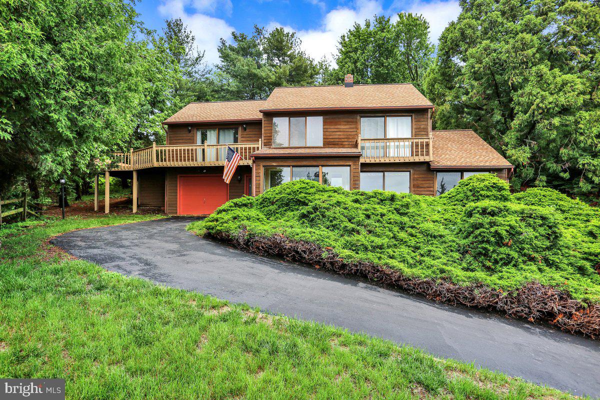 a front view of a house with a yard and trees