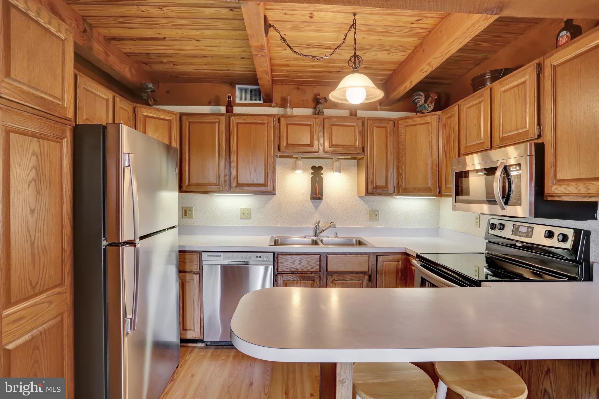 55 Karen Court Lititz, PA 17543 - Photo 10 of 36 a kitchen with stainless steel appliances granite countertop a sink a refrigerator and wooden cabinets