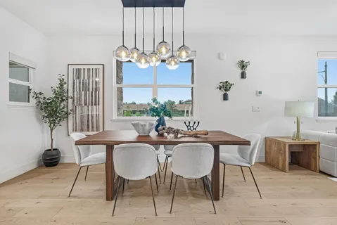 a view of a dining room with furniture a chandelier and wooden floor