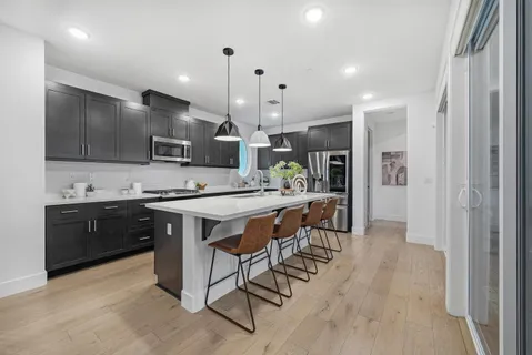 a kitchen with kitchen island granite countertop a sink counter top space stainless steel appliances and cabinets