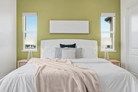 a bedroom with a bed and a painting on the wall