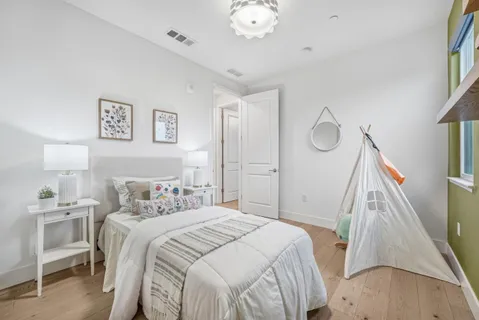 a bedroom with a bed and a flat tv screen on dresser