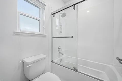 a bathroom with a toilet and a shower