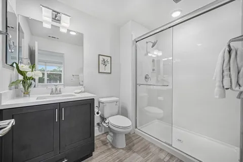 a bathroom with a toilet sink a shower and a mirror