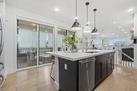 a kitchen with stainless steel appliances granite countertop a sink a stove and a wooden floors