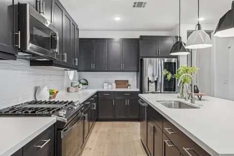 a kitchen with stainless steel appliances a sink stove and cabinets