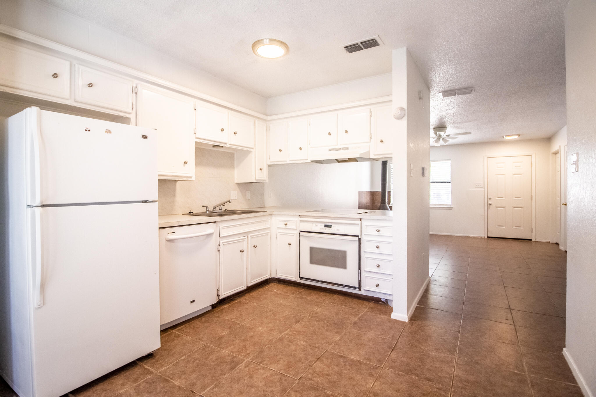 a kitchen with white cabinets and white appliances