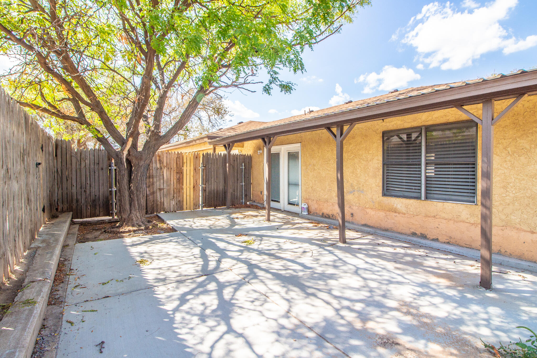 6103 38th Street, Unit B Lubbock, TX 79407 - Photo 11 of 11 a view of backyard with large trees and wooden fence