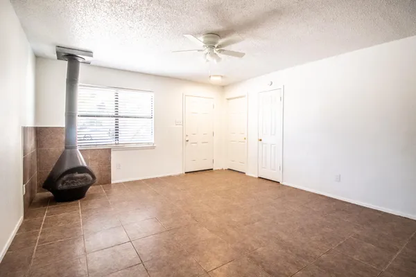 an empty room with windows and fan