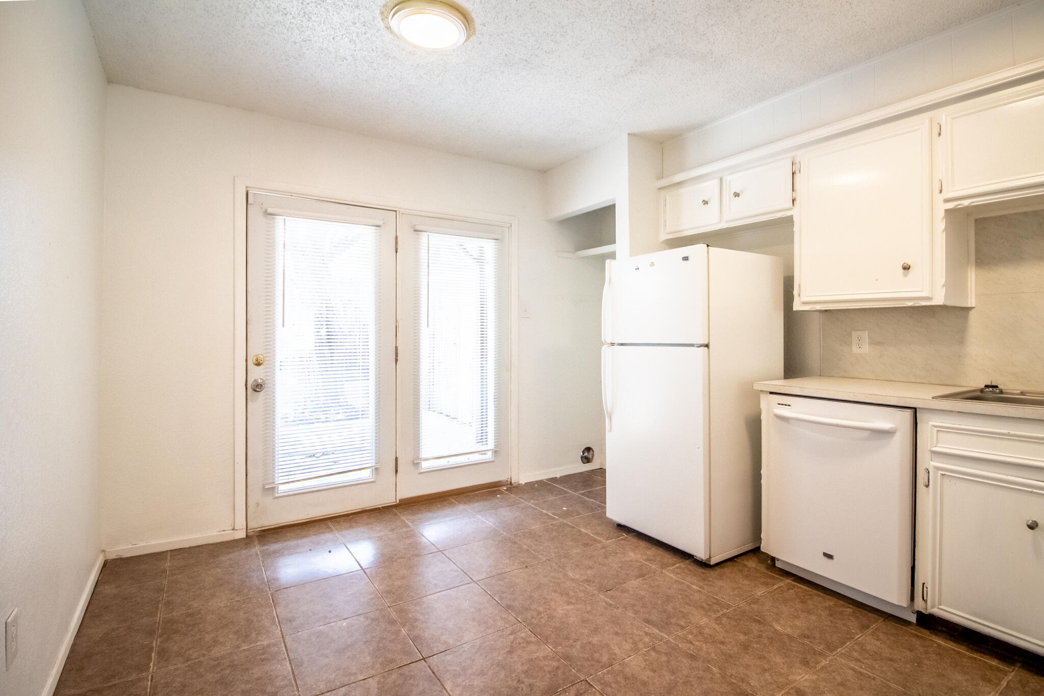6103 38th Street, Unit B Lubbock, TX 79407 - Photo 5 of 11 a view of a kitchen with refrigerator and white cabinets