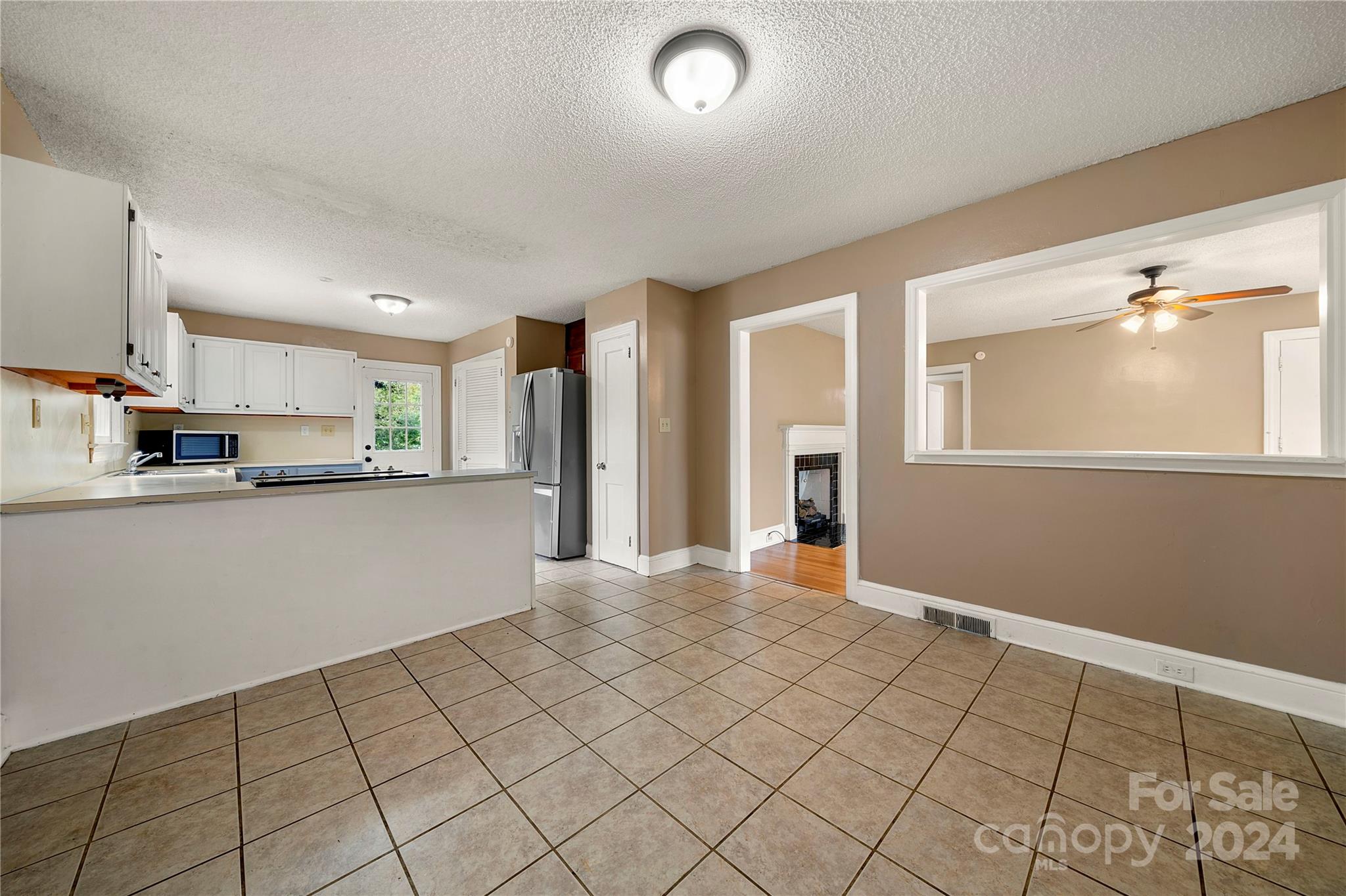 8101 Plott Road Charlotte, NC 28215 - Photo 11 of 34 a view of kitchen with refrigerator cabinets and window