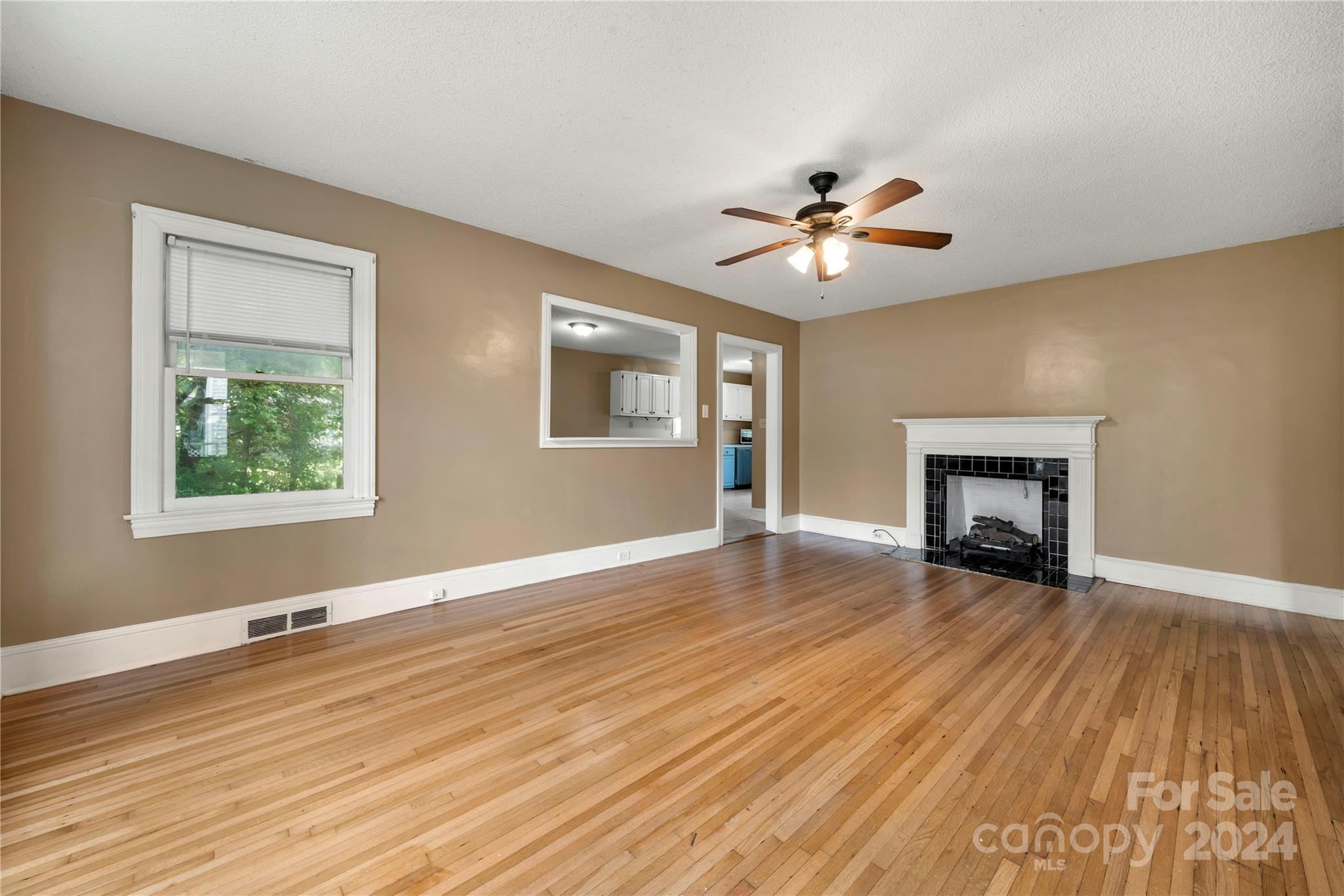 8101 Plott Road Charlotte, NC 28215 - Photo 7 of 34 a view of empty room with wooden floor and fireplace