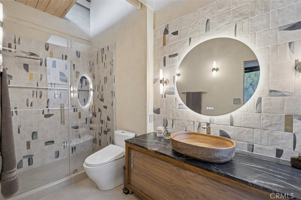 21090 Rios Street Woodland Hills, CA 91364 - Photo 32 of 61 a bathroom with a granite countertop sink toilet a mirror and shower