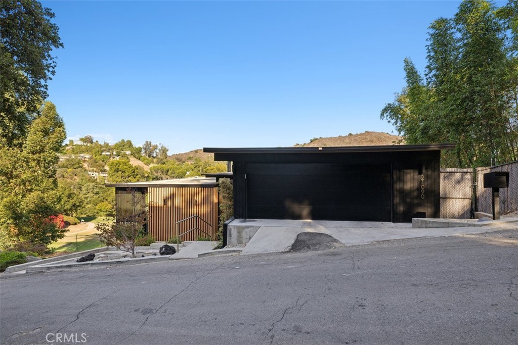 21090 Rios Street Woodland Hills, CA 91364 - Photo 48 of 61 a front view of a house with a yard and garage