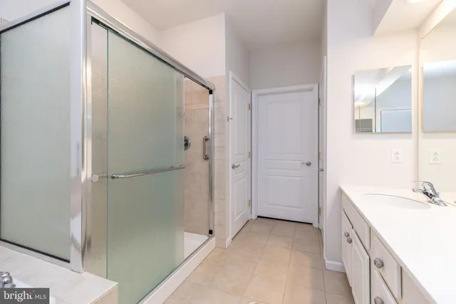 a spacious bathroom with a tub sink and mirror