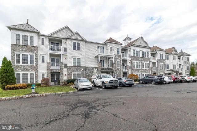 a front view of a building with cars parked