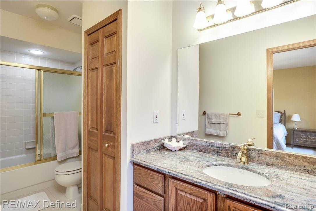 4140 Ridge Side Drive Rochester, MI 48306 - Photo 28 of 42 The second bedroom's private bathroom features tile flooring and granite counters.