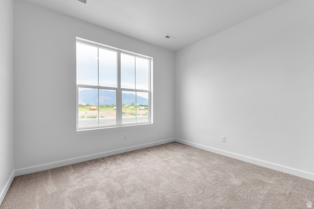 1869 South 2425 West Ogden, UT 84401 - Photo 7 of 22 Spare room with light colored carpet and a mountain view