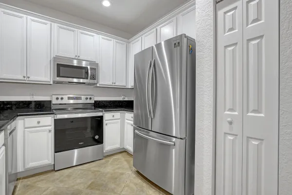 a kitchen with stainless steel appliances white cabinets and a refrigerator