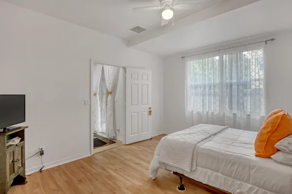 a bedroom with a bed and a flat tv screen on a dresser