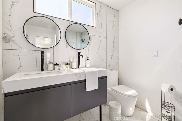 a bedroom with a bed a couch and painting on the wall